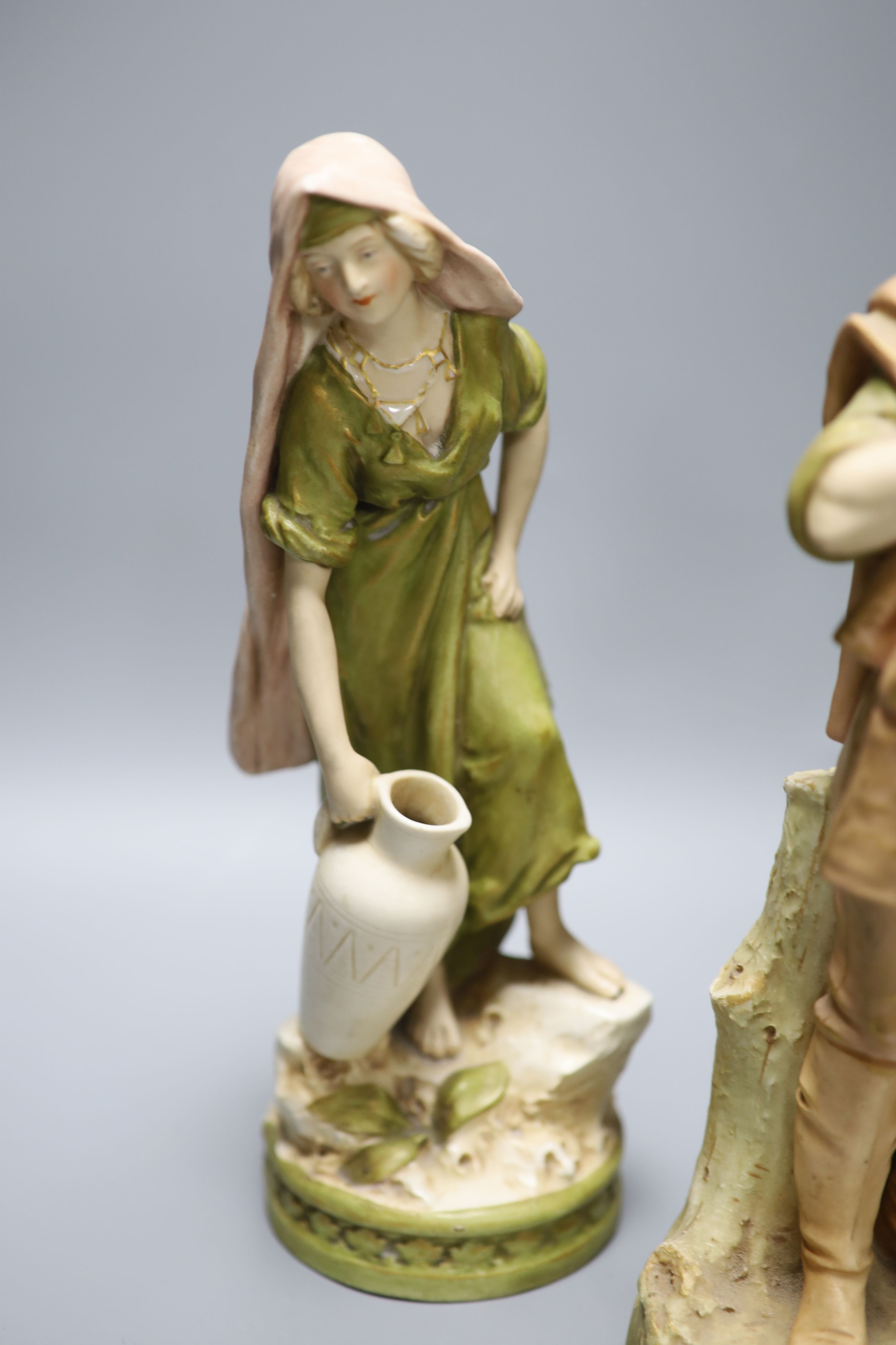 A pair of Royal Dux female water carriers and another of a farmer, 32cm